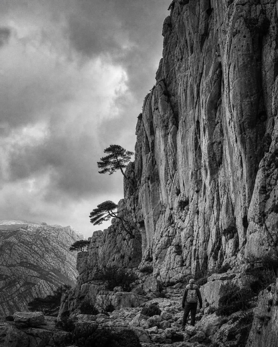 Un randonneur solitaire contemple la face nord sauvage de la Sainte-Victoire, avec ses profondes crevasses et ses pins d
