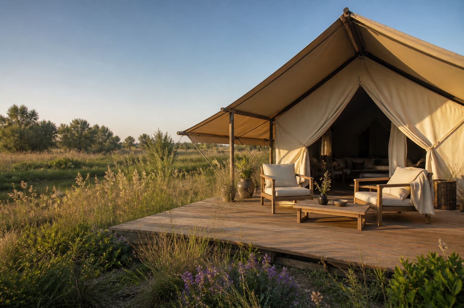 Tente lodge safari avec terrasse en bois ouverte sur un paysage naturel de Camargue
